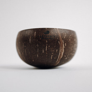 A natural brown coconut bowl with a logo in the center, placed on a white background.